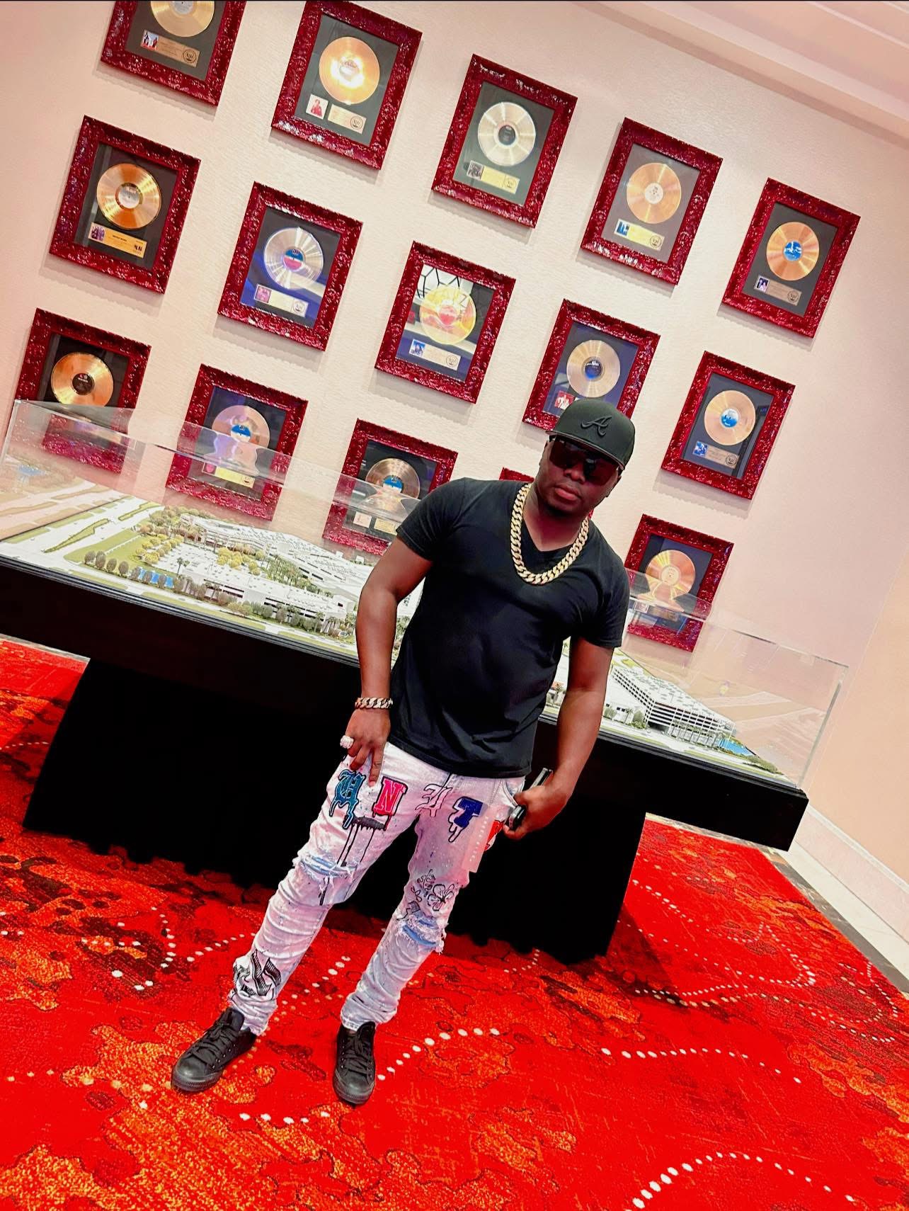 Tilt standing in front of a wall of gold records